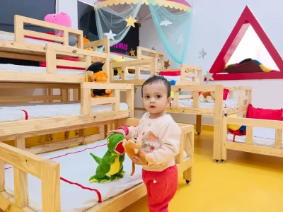 A toddler with soft toys in the cosy Pre Nursery nap room