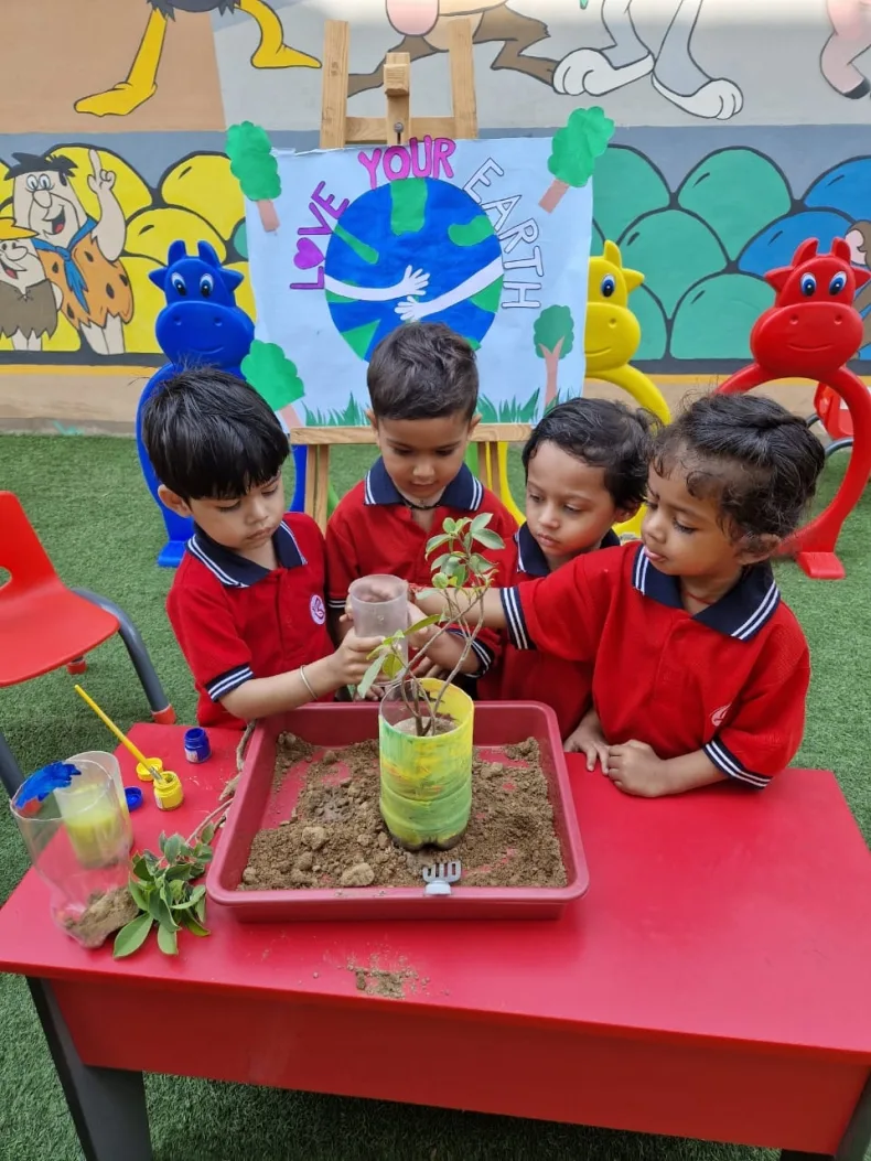 Children potting a sapling together for World Earth Day