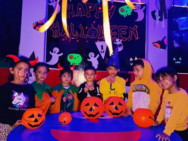 Children in Halloween costumes posing with jack-o-lantern buckets