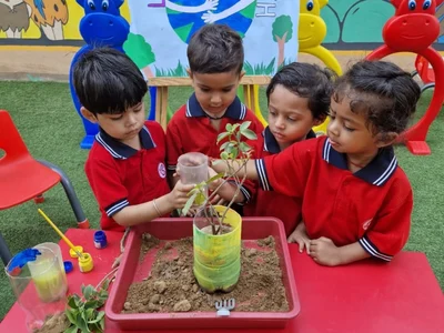 Children potting a sapling together during a nature activity