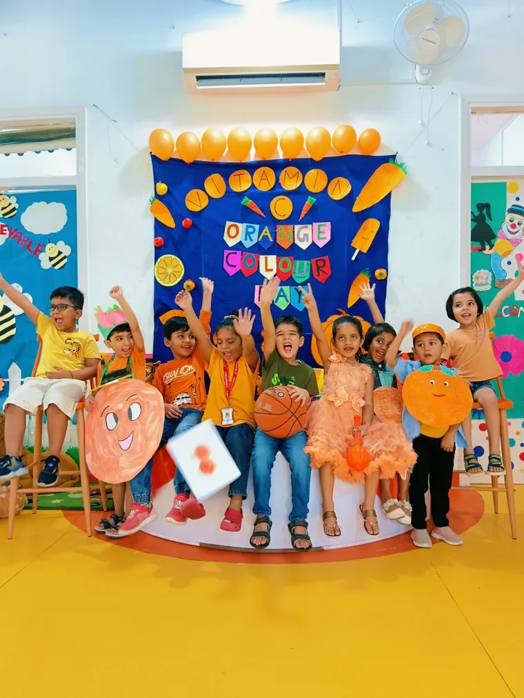 Children dressed in orange celebrating Orange Colour Day in a decorated classroom