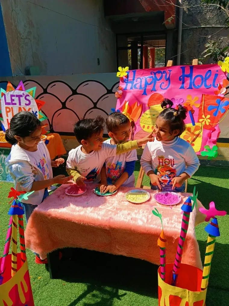 Children playing with colours on the school lawn during the Holi celebration