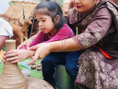 A teacher guiding a child’s hands during a hands-on activity